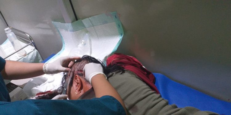 ISTIMEWA FOTO, Admnini (45) menerima tindakan medis usai menjadi korban pembacokan OTK di kiosnya.
